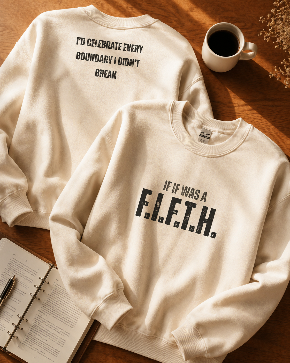 A folded cream hoodie beside a journal and mug of tea